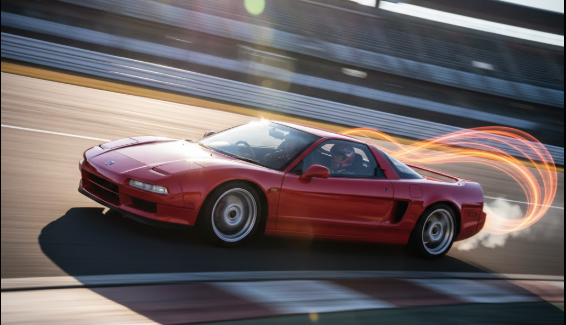 日本人男性が運転するホンダNSXが、サーキットのコーナーを駆け抜ける様子をローアングルから捉えた写真。スピード感のあるブレが、高回転域で響き渡るVTECサウンドを視覚的に表現している